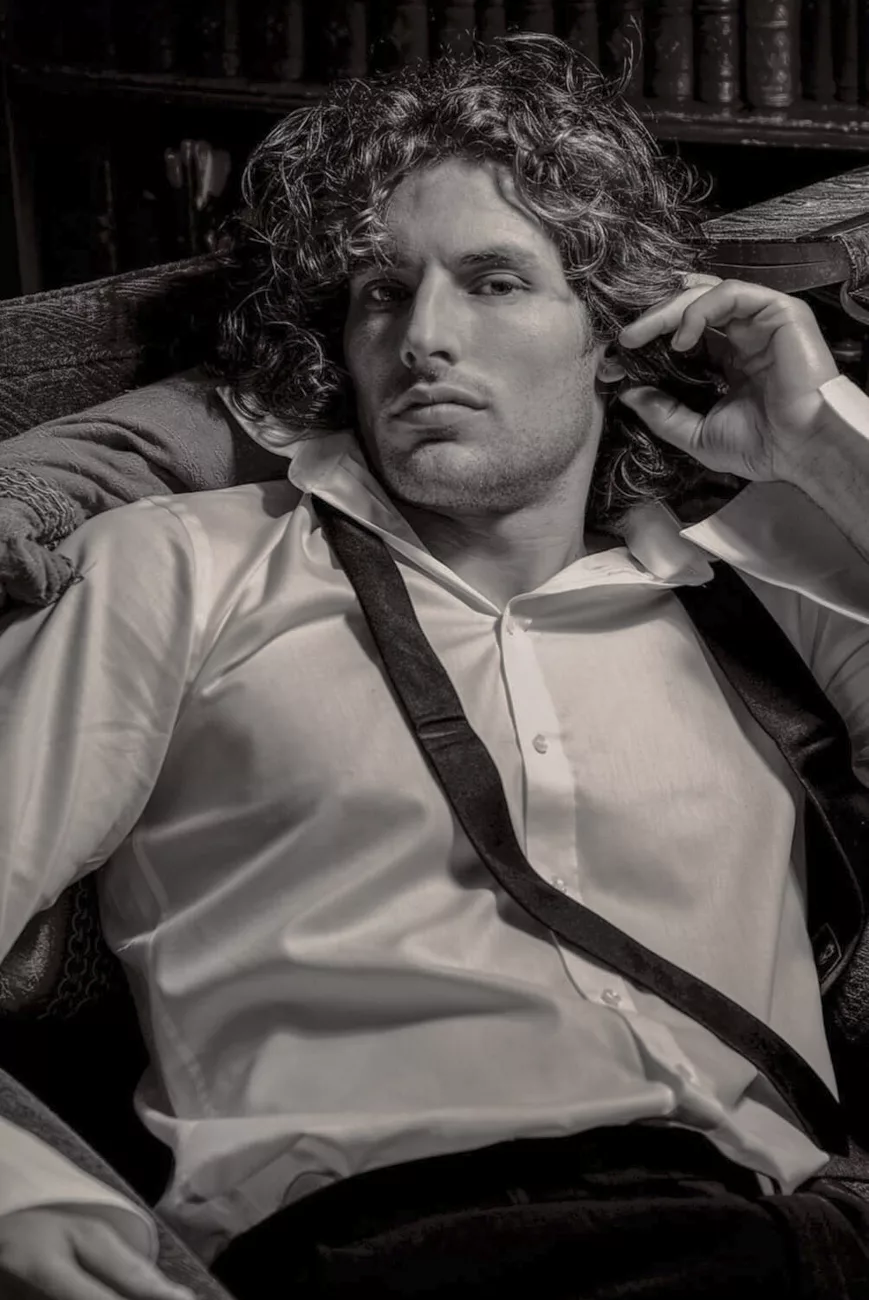 Black and white mens fashion portrait by photographer James Nader showing relaxed editorial posing and directional light