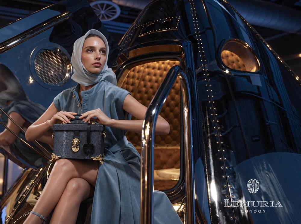 Luxury fashion model holding a Lemuria London bag beside the Apollo capsule during a London campaign shoot
