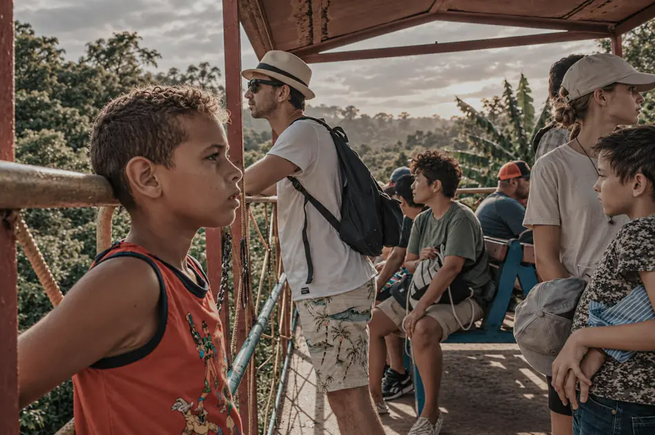 Candid scene with passengers and children on an outdoor viewing platform in Cuba, photographed by James Nader